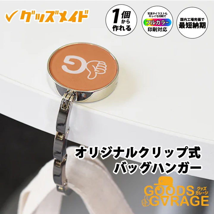 オリジナルクリップ式バッグハンガー。
フルカラー印刷対応で、1個からオリジナル制作が可能なバッグハンガーです。
天板部分にロゴやイラストを印刷したサンプル例。
